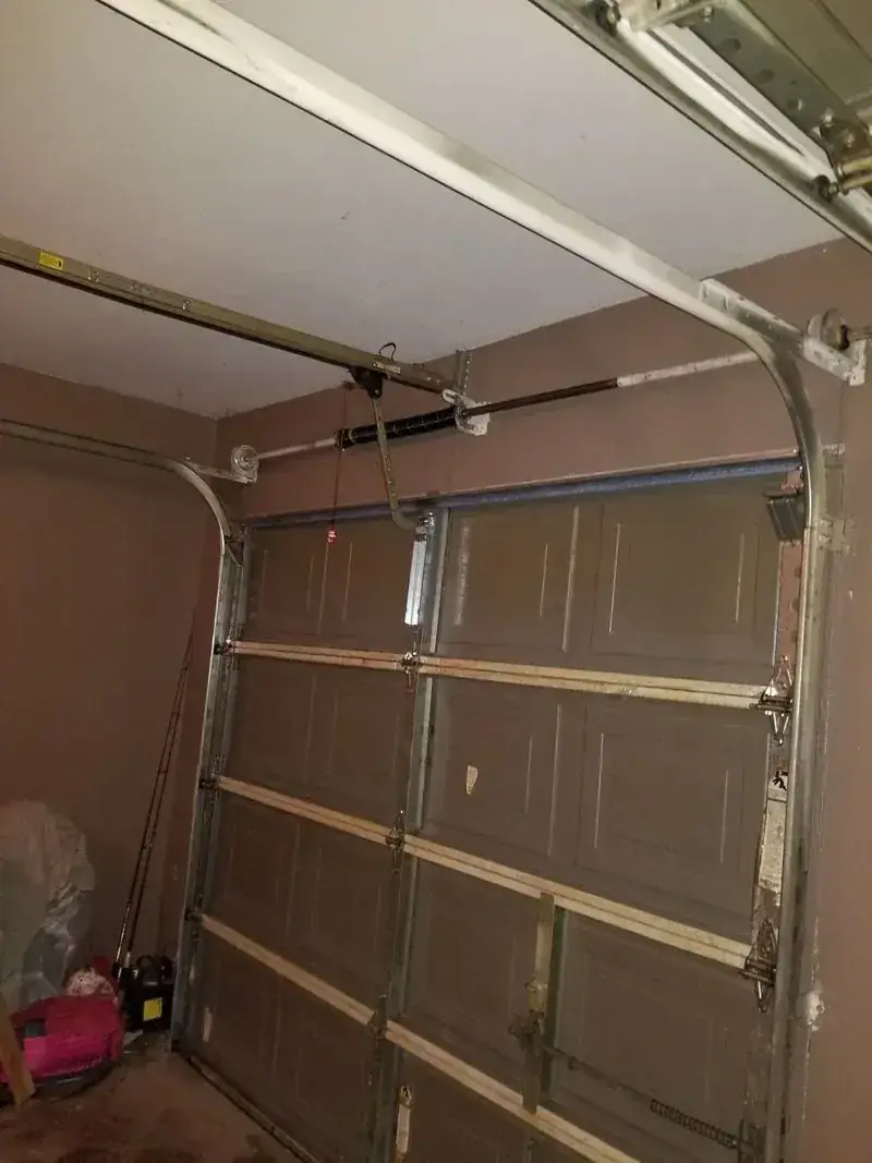 A garage door is open and sitting in a garage.