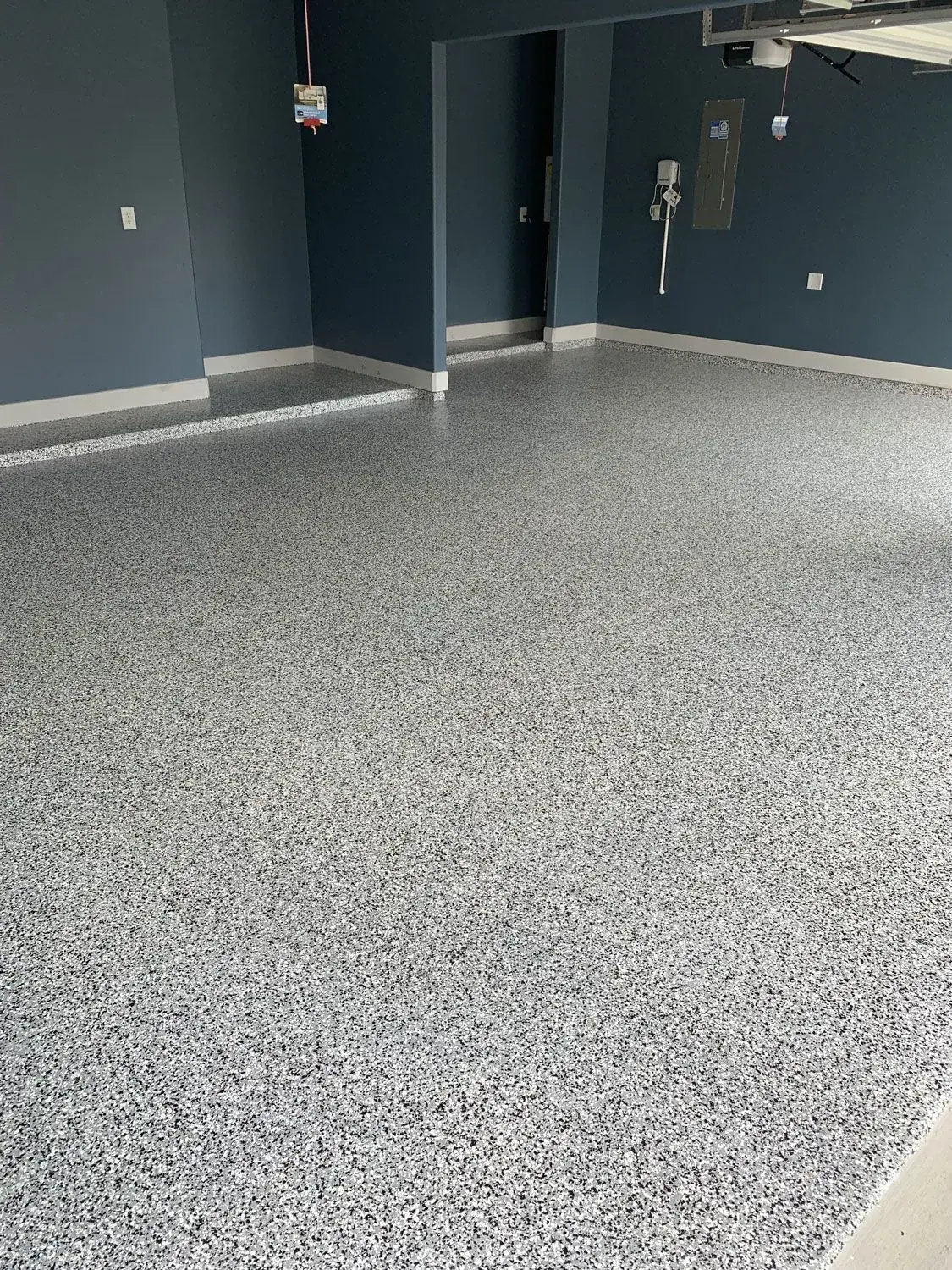 A garage with a gray floor and blue walls.