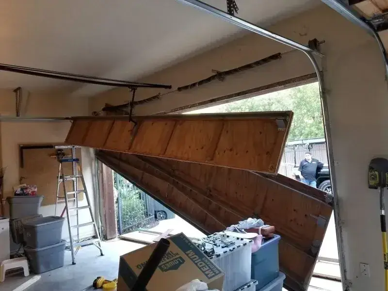 A garage with a broken garage door and boxes in it